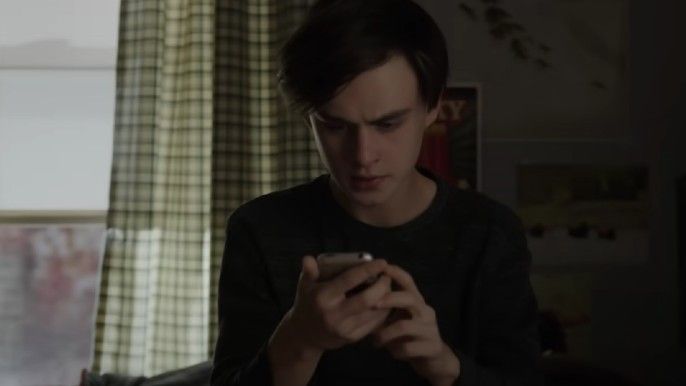Jaeden Martell as Craig looking at iPhone in his hand in Mr. Harrington's Phone