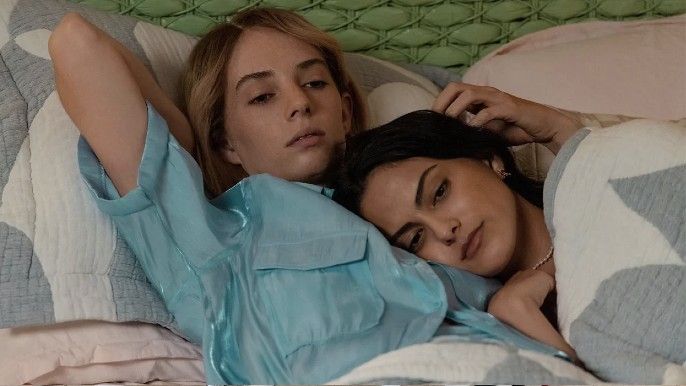 Do Revenge Camila Mendes as Drea resting head on Maya Hawke as Eleanor chest in bed