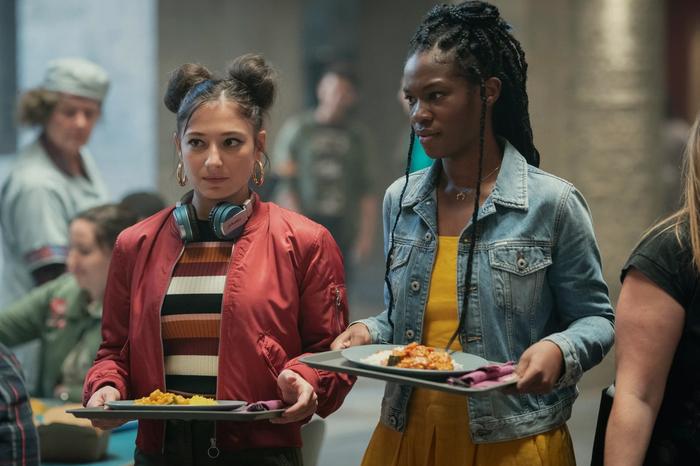 Fate: the winx saga season 1 Elisha Applebaum as Musa and Precious Mustapha as Aisha hold cafeteria tray and look at something