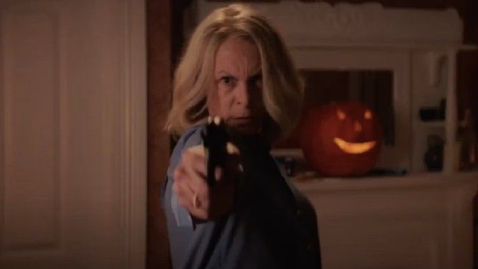 halloween ends Jamie Lee Curtis as Laurie Strode holds gun to michael myers