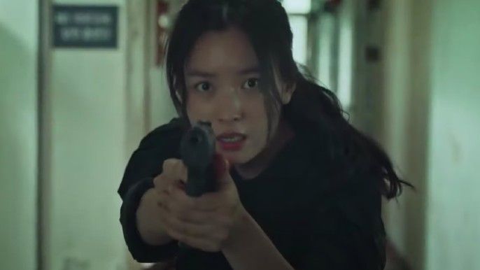 Happiness Han Hyo-Joo as Yoon Sae-bom holding a gun towards camera
