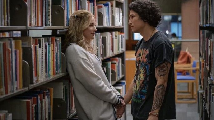 Look Both Ways lili reinhart as natalie, danny ramirez as gabe in library looking at each other passionately