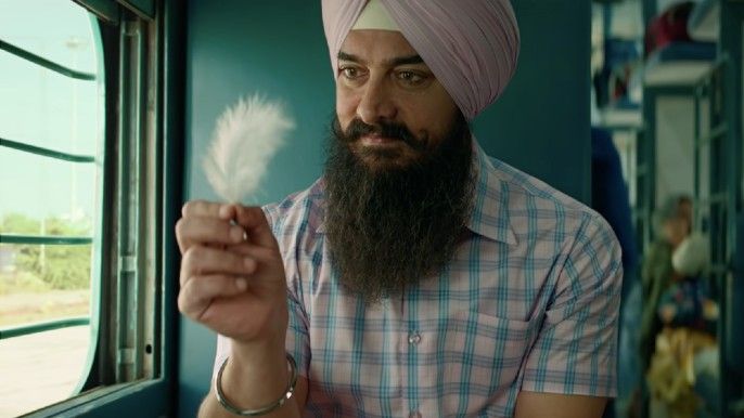 Aamir Khan as Laal Singh Chaddha holding a feather in Laal Singh Chaddha