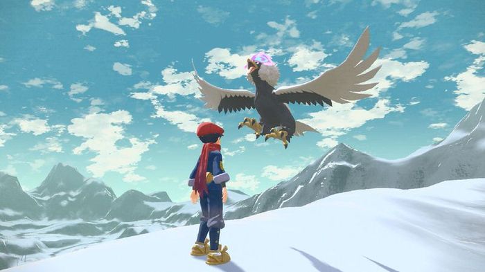 Hisuian Braviary, a magnificent eagle, hovers on a snowy mountaintop next to a trainer.
