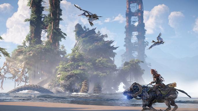 Horizon Forbidden West. Aloy riding a charger across the beach with a set of ancient buildings in the background