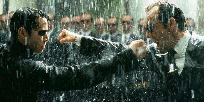 Neo and Agent Smith are close to punching each other in the rain.