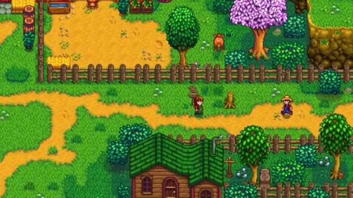 Stardew Valley. The player is walking past a citizens house and the dairy farm. The dairy farm is at the top of the image and the villager's house is at the bottom. The player is walking along a dirt path between the two. 