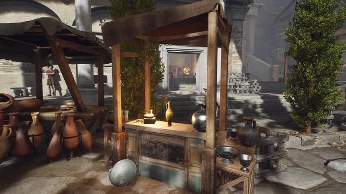 The Forgotten City. Desius's stall. The wooden stall has three items on it and a bottle with a yellow stripe around the center in the middle of the table. There is a pot in front of the stall. The vendor is not there. 