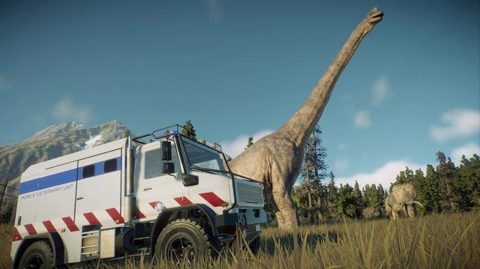 Jurassic World Evolution 2. A white Medical Vet Unit truck can be seen driving in front of a sick Brachiosaurus dinosaur. 