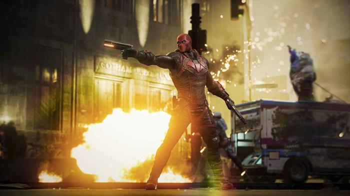 Red Hood firing a gun in front of an explosion in Gotham Knights.