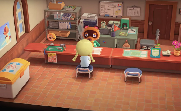 The Resident Representative is talking to Tom Nook at the Construction Desk in the Town Hall.