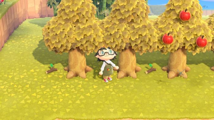 A player stood by trees with Tree Branches below them in Animal Crossing: New Horizons.
