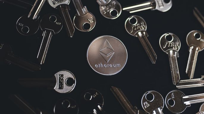Ethereum silver coin on black surface surrounded by keys.