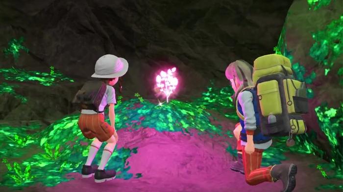 Image of two trainers looking at a glowing orb in Pokémon Scarlet and Violet