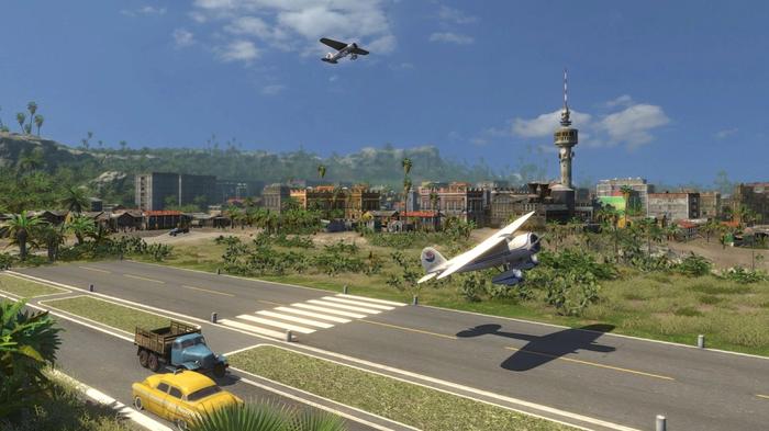 Two planes fly across an airport in Tropico
