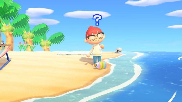 Animal Crossing New Horizons. The player is stood on a beach with a question mark above their head as they look down at a rainbow message bottle.