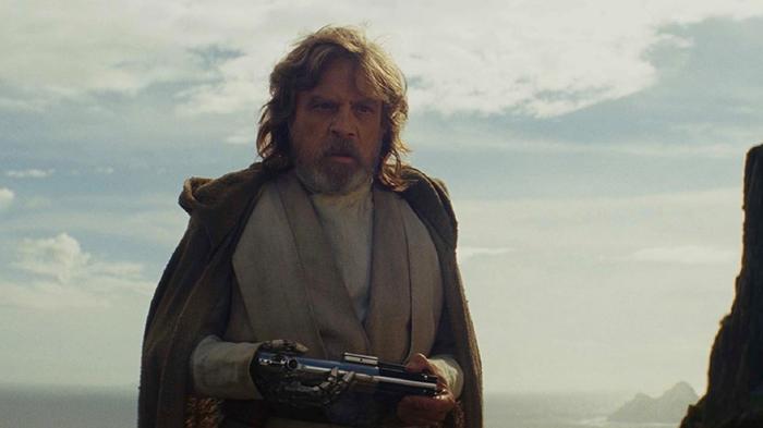 Luke Skywalker holds a lightsaber.