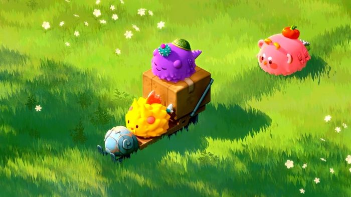 Axie Infinity characters on grassy background.