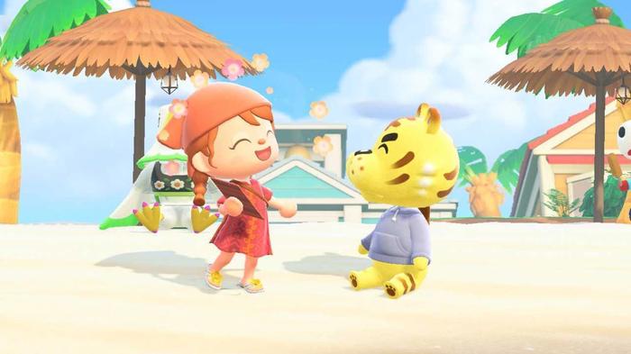 Animal Crossing New Horizons Happy Home Paradise - the player is on the left and happily talking to a tiger sitting down on the right. They are both on the beach with beach umbrellas behind them. 