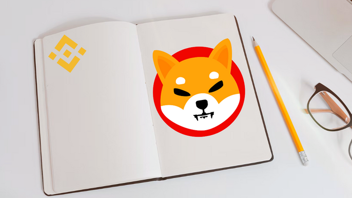 Shiba Inu (SHIB) logo on a page in a notebook, next to a pencil and glasses. On the left page, is a Binance logo