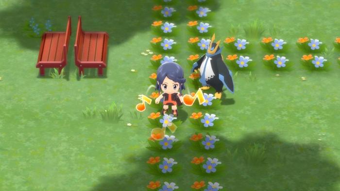 A Pokémon Trainer walking with their Empoleon in Amity Square of Hearthome City in Pokémon Brilliant Diamond and Shining Pearl.