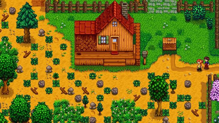 Stardew Valley. Standard farm. The image shows the starter house and plot for the Standard Farm. There is a small wooden building with a red roof near the back. The ground in front of the house is littered with trees, rocks, overgrown plants and sticks. The player is on the right of the screen near the house. The trees are all vibrant and green as it's spring. 