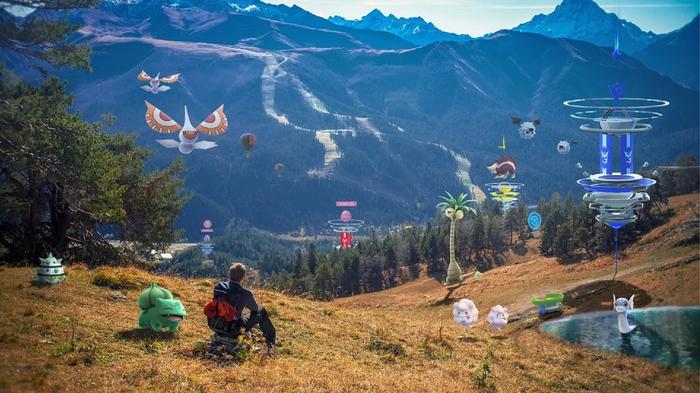 A trainer sits on an IRL mountainside surrounded by Pokémon.