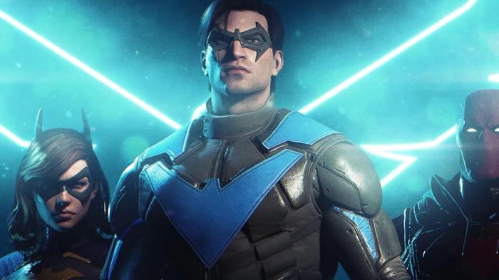 Nightwing stood behind a neon light in Gotham Knights.