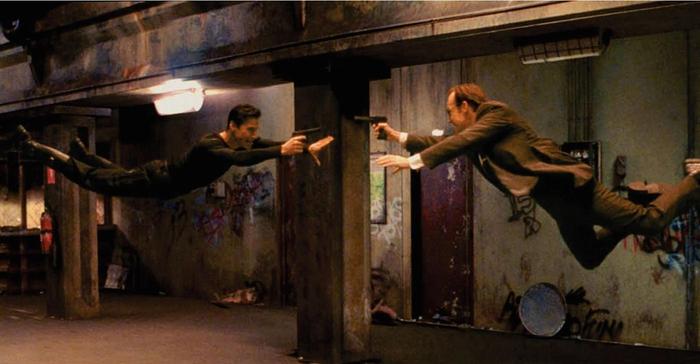 Neo and Smith jump at each other in mid-air.