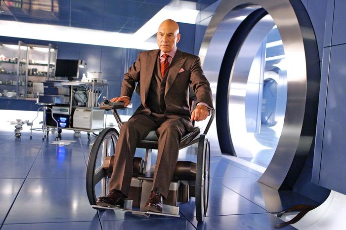 Professor Xavier is travelling through a room on a wheel-chair.