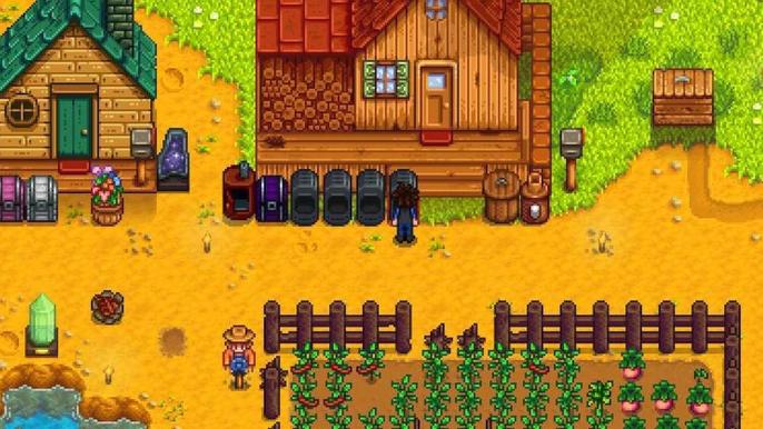 Stardew Valley. The player is facing one of their four furnaces that are lined up by their house. Crops can be seen in a rectangular formation on the lower half of the screen. The four furnaces are black and lined up in front of the main house. On the left of the screen there is a small house with a green roof. 