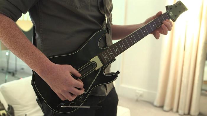 Image of person holding Guitar Hero controller