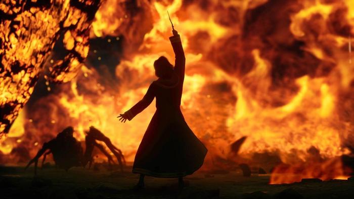 A witch casting a spell in front of a fiery backdrop in Hogwarts Legacy.