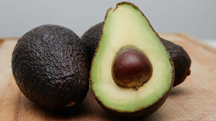 Picture of three avocados, one of which is cut in half.
