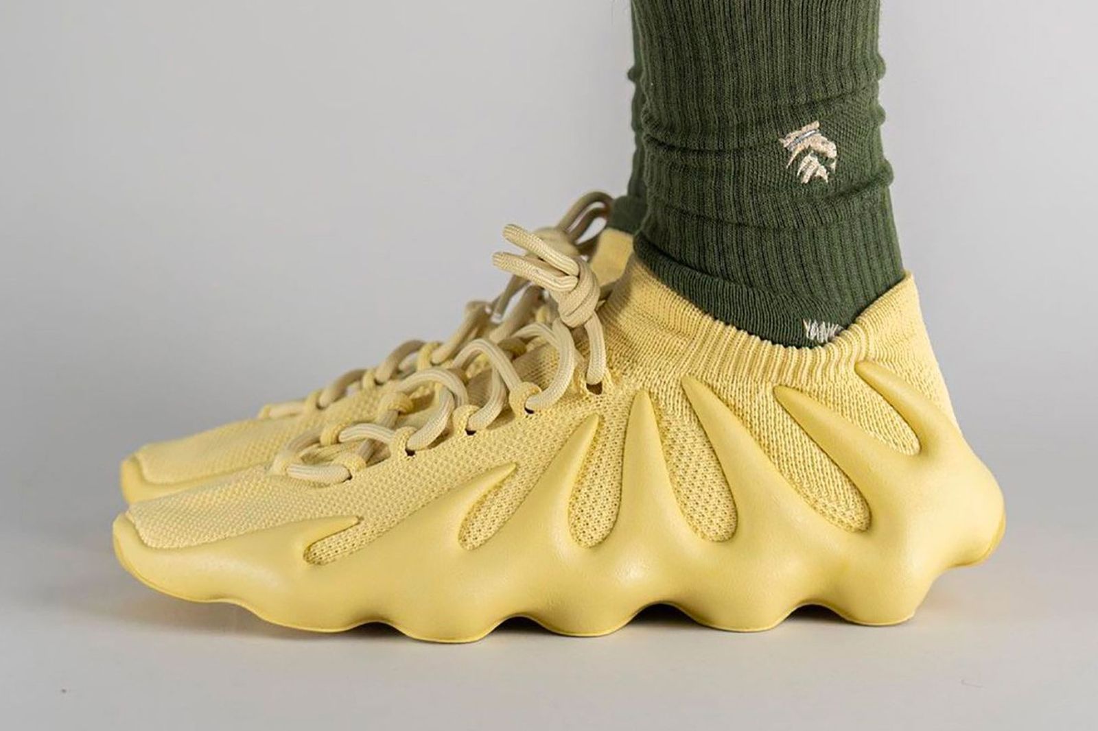 adidas Yeezy 450 "Sulfur" on-foot image of yellow PrimeKnit sneakers.