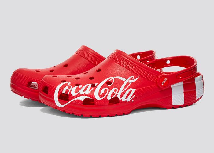 Coca-Cola x Crocs Classic Clogs product image of a red pair of Crocs with white Coca-Cola branding along the sides.
