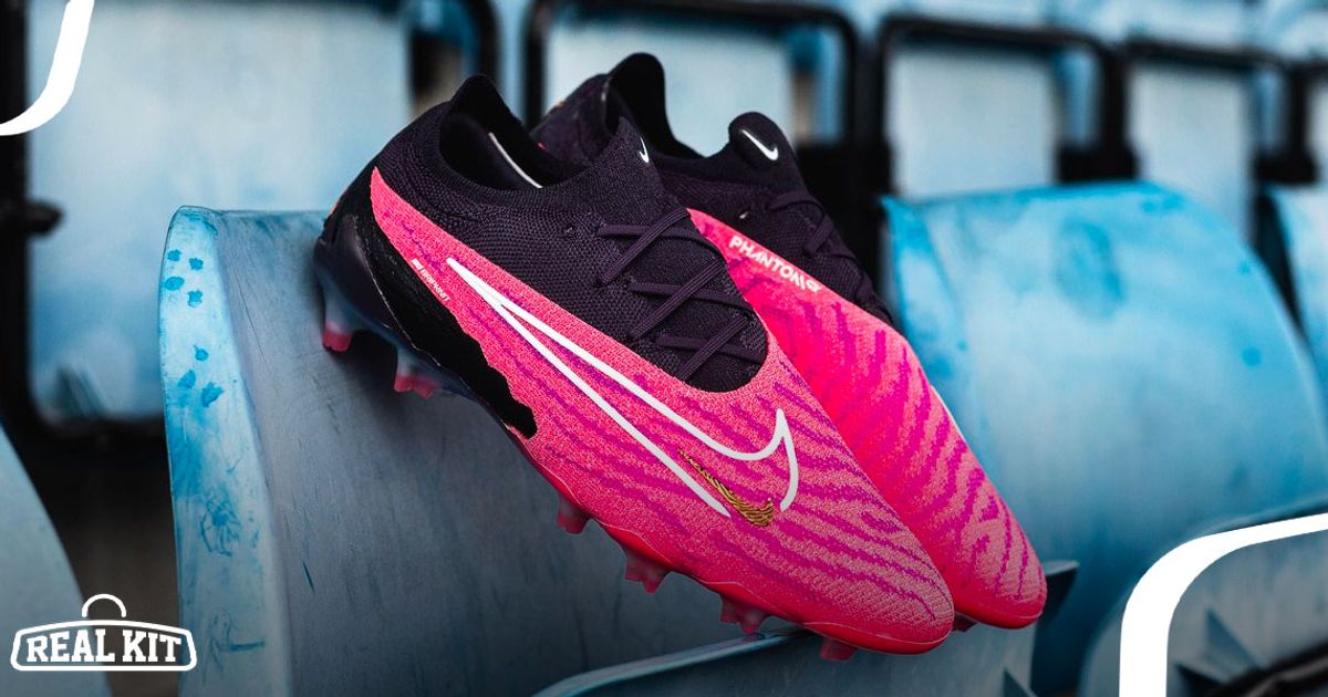 Close-up of a pair of pink Nike boots with black collars and laces lent against a blue stadium seat.
