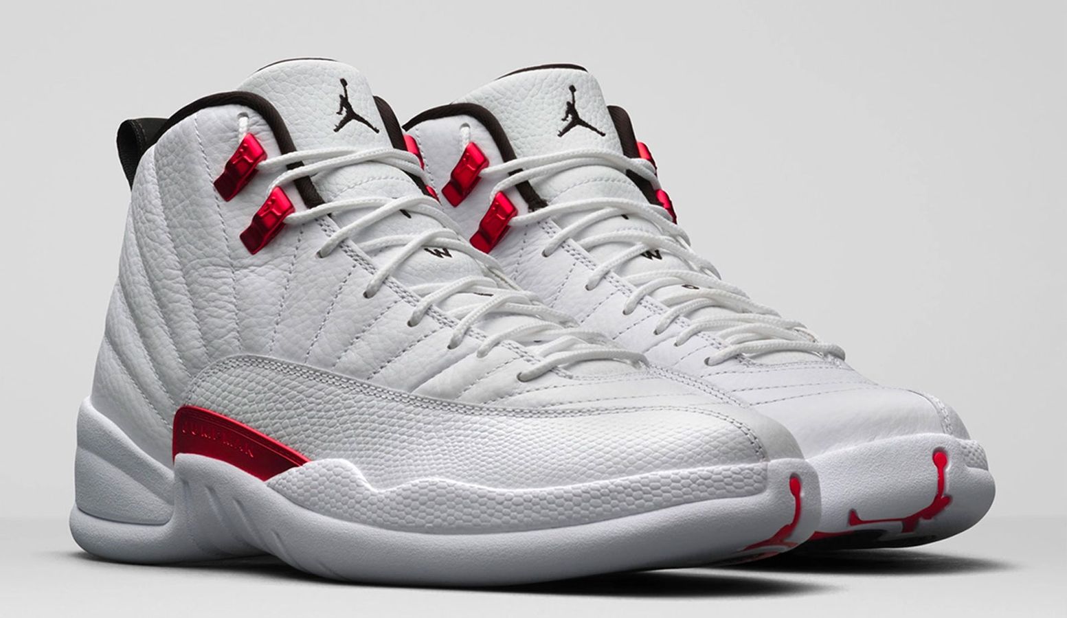 Best Air Jordan 12 colorways "Twist" product image of a pair of white sneakers with red accents.