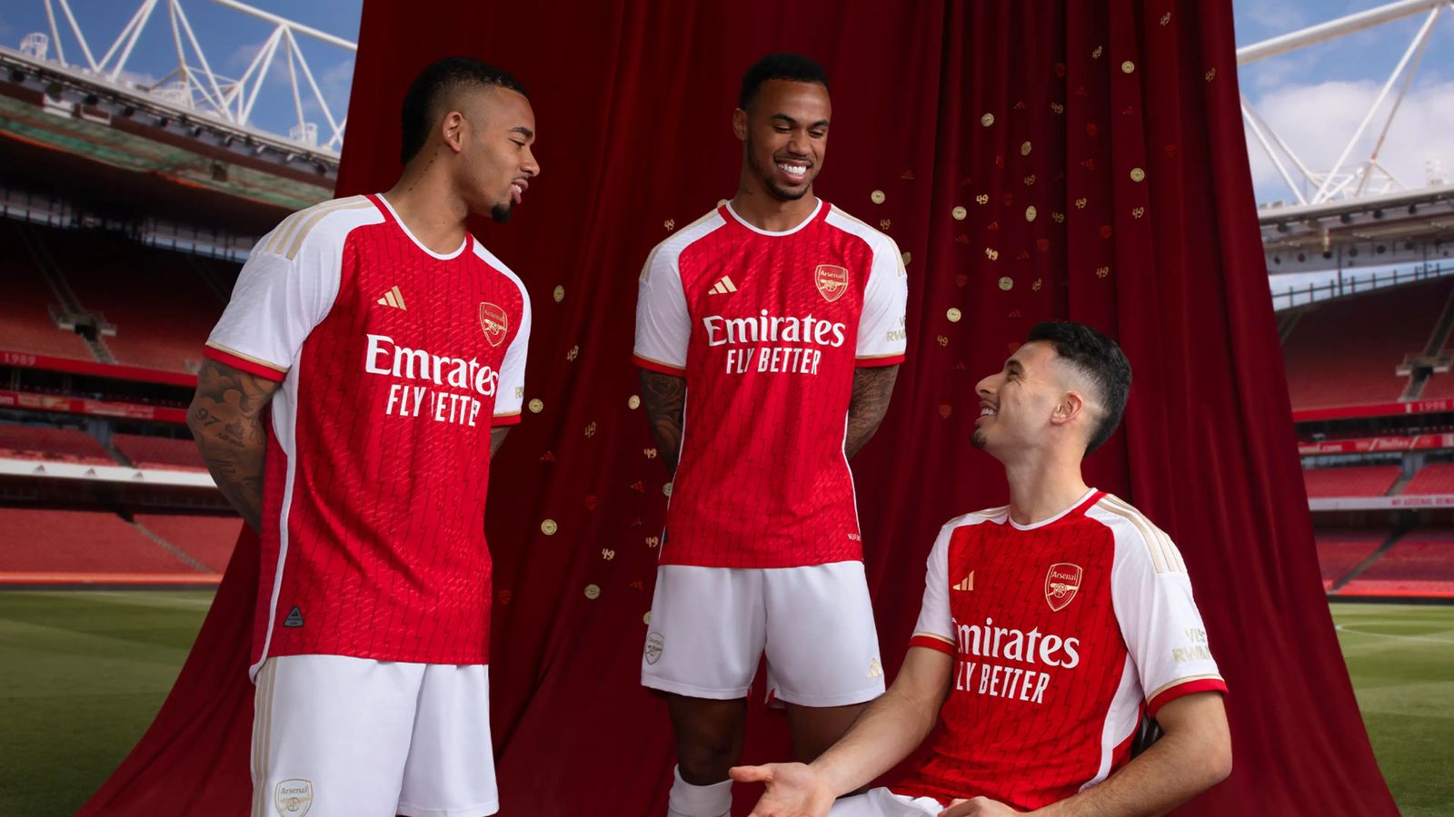 Arsenal adidas Home Kit product image of Jesus, Gabriel, and Martinelli wearing red and white kits with golden details.