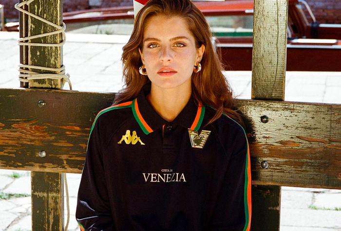 Best football kits 2022/23 Venezia home kit product image of a black shirt with orange and green stripes down the sleeves and golden accents.