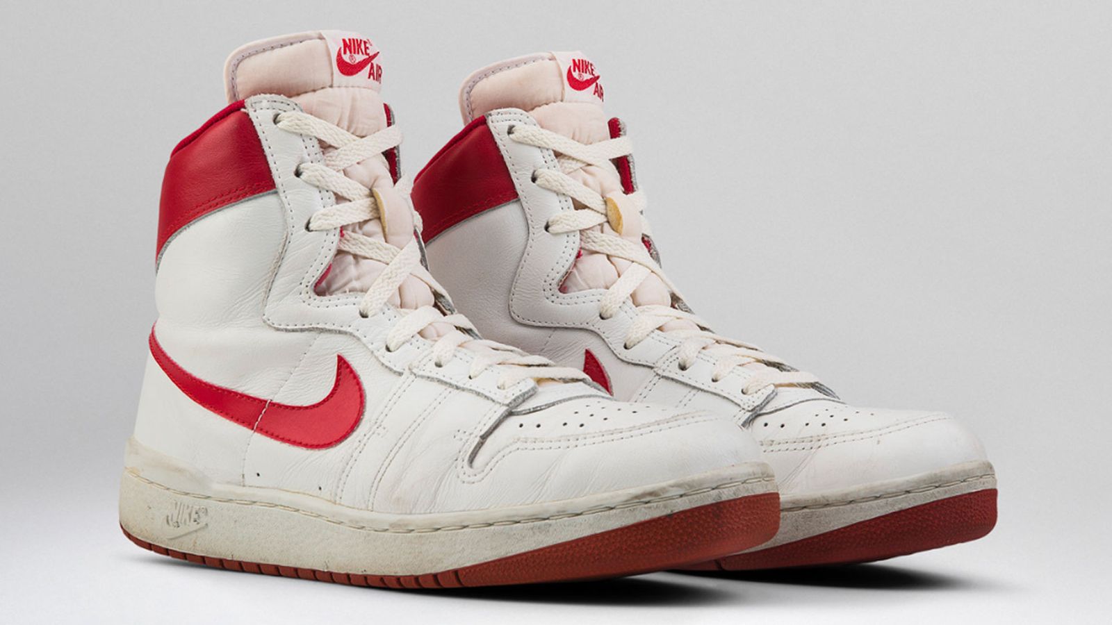 Image of Nike Air Ship a pair of white and red high-top Air Ship sneakers.