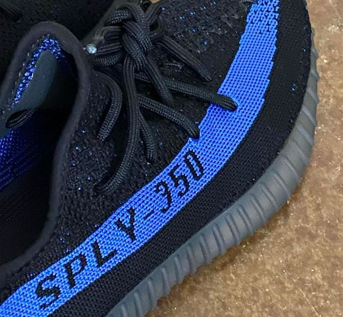 Yeezy Boost "Dazzling Blue" product image of a black sneaker with a blue streak.