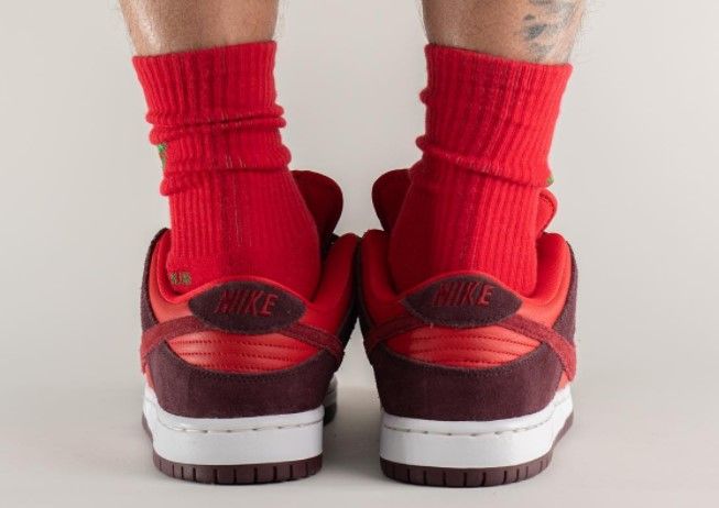 Nike SB Dunk Low "Cherry" product image of a red suede pair of sneakers with burgundy overlays and white midsoles.