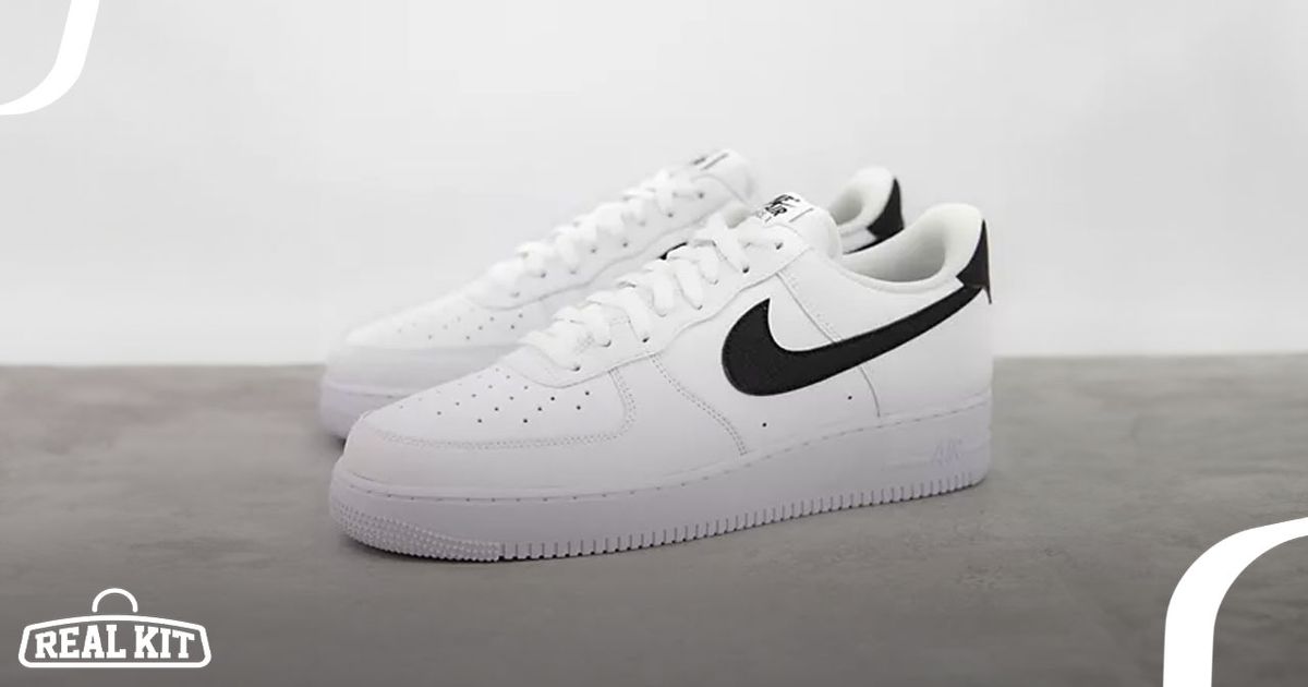 A white leather Air Force 1 low-top featuring a black Swoosh down the side and a black heel.
