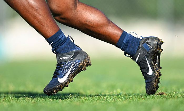 Nike product image of a pair of high-top black cleats.