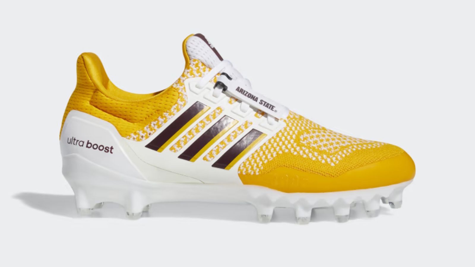 adidas Ultraboost 1.0 product image of a yellow fabric cleat featuring white TPU overlays and maroon details.