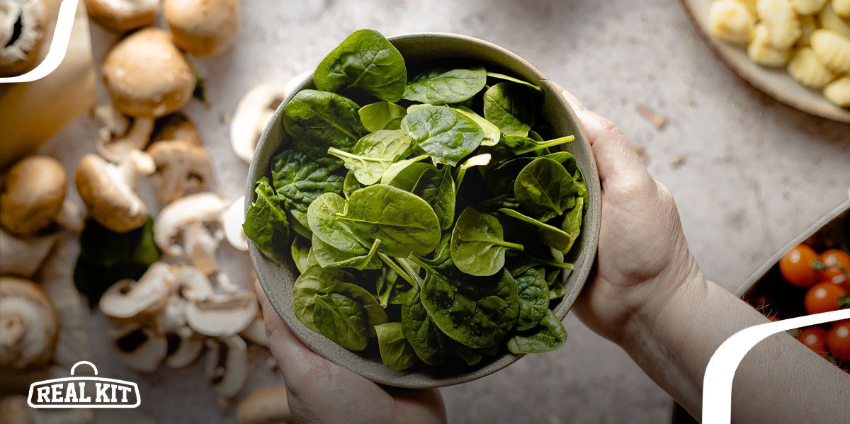 Image of someone holding a bowl of green spinach.