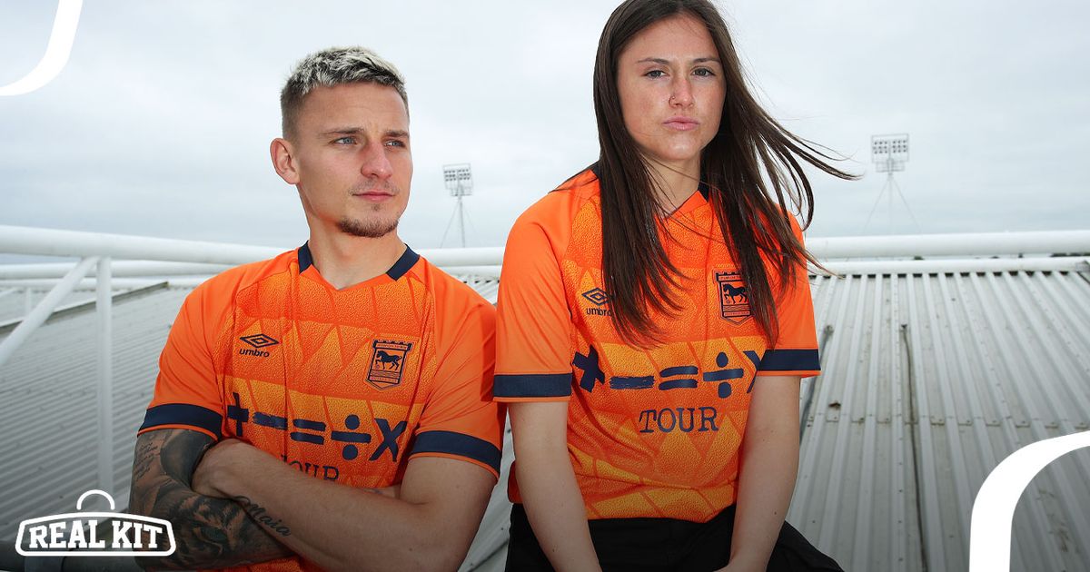 Two people in the stands wearing orange Ipswich Town kits featuring black trims.
