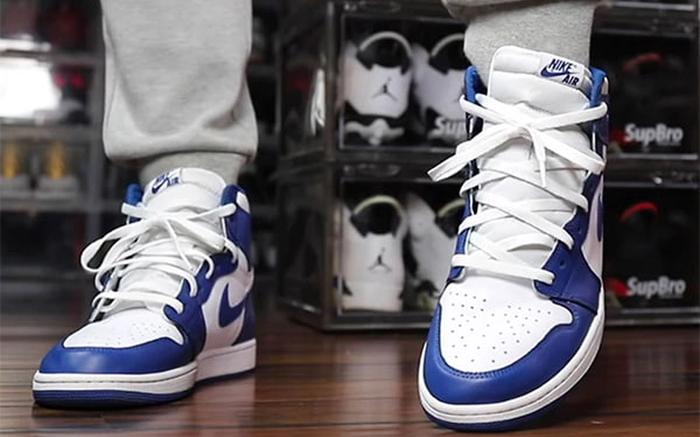 How to lace Jordan 1 - Air Jordan 1 loosely crossed laces image of a pair of white sneakers with blue overlays and white sneakers loosely crossed.