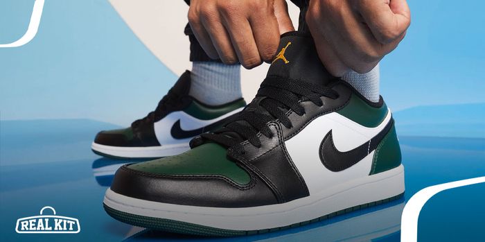 Image of someone pulling the tongue of a black, white, and dark green Jordan 1 Low.